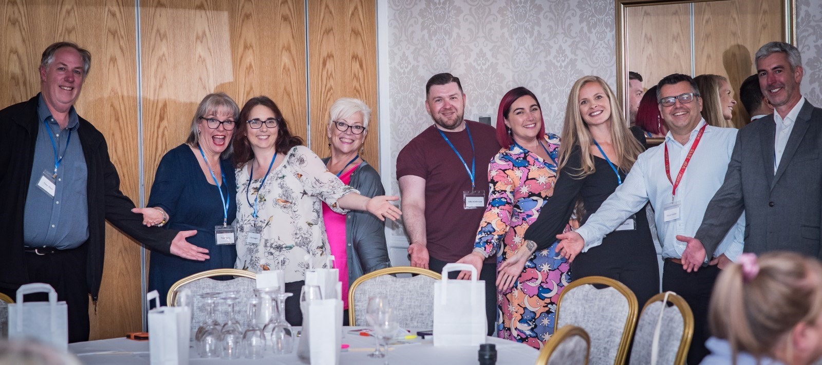 Attendees of INDICRO launch event at Shendish manor around a table smiling with their arms out